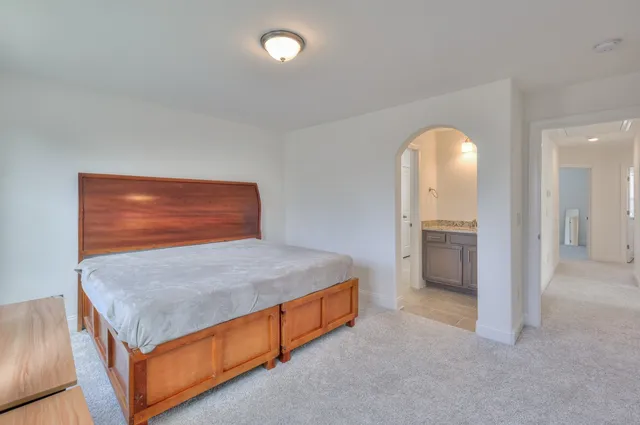 a room with a bed and a view of living room