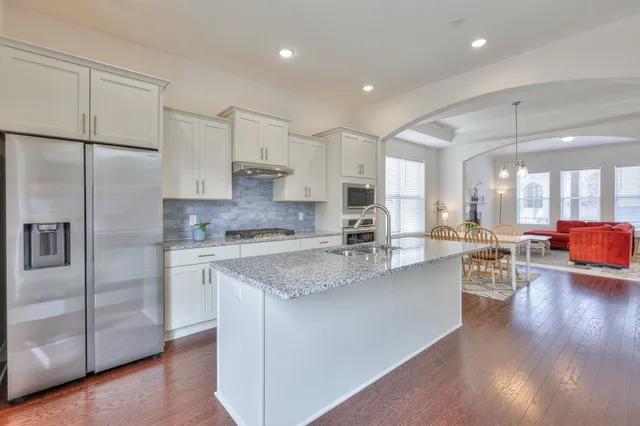 a kitchen with stainless steel appliances granite countertop a refrigerator sink and cabinets