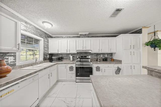 a kitchen with a refrigerator and chairs