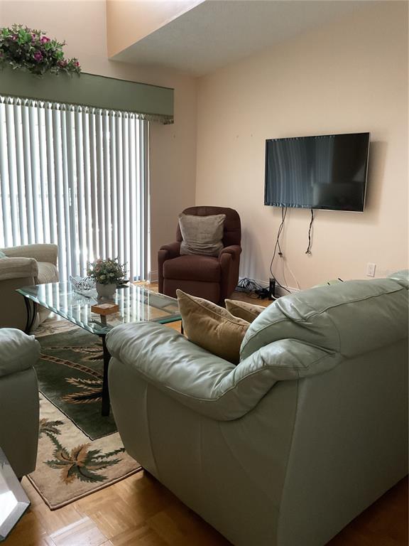 2655 Pine Ridge Way North, Unit D3 Palm Harbor, FL 34684 - Photo 8 of 31 a living room with furniture and a flat screen tv