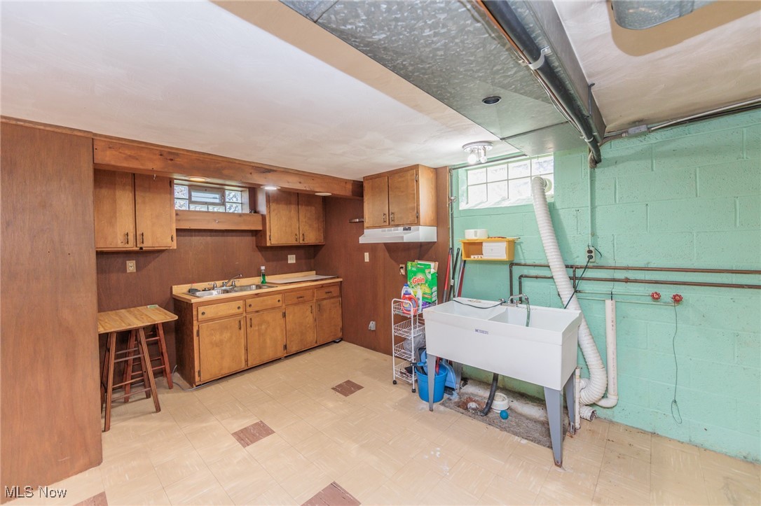 5445 Hauserman Road Cleveland, OH 44130 - Photo 37 of 45 Basement with sink, wooden walls, and light tile patterned floors