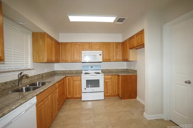 a kitchen with a white stove top oven sink and cabinets