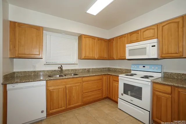a kitchen with granite countertop cabinets stainless steel appliances and a sink