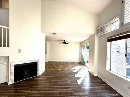 a view of an empty room with a fireplace and a window