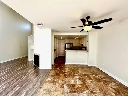 a view of a hallway with wooden floor and a ceiling fan