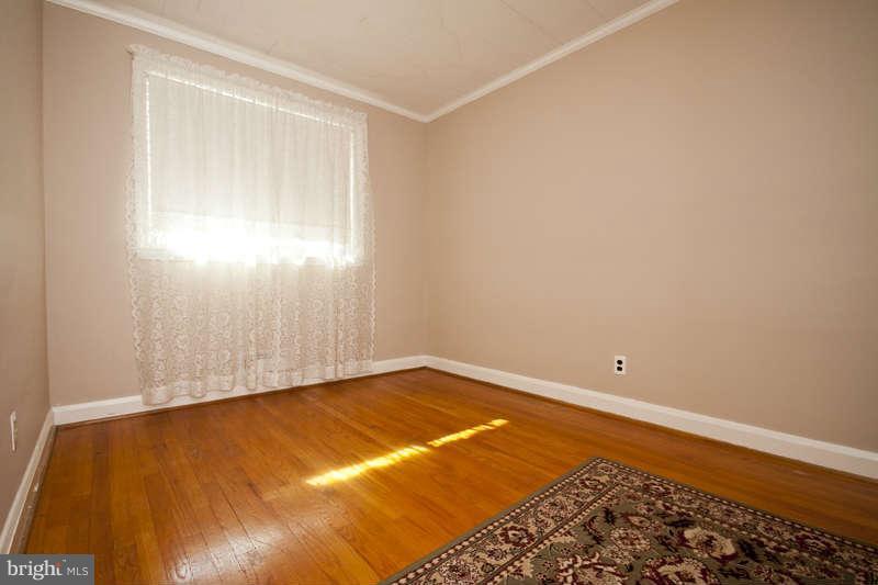 1932 Church Road Baltimore, MD 21222 - Photo 21 of 27 an empty room with wooden floor and windows