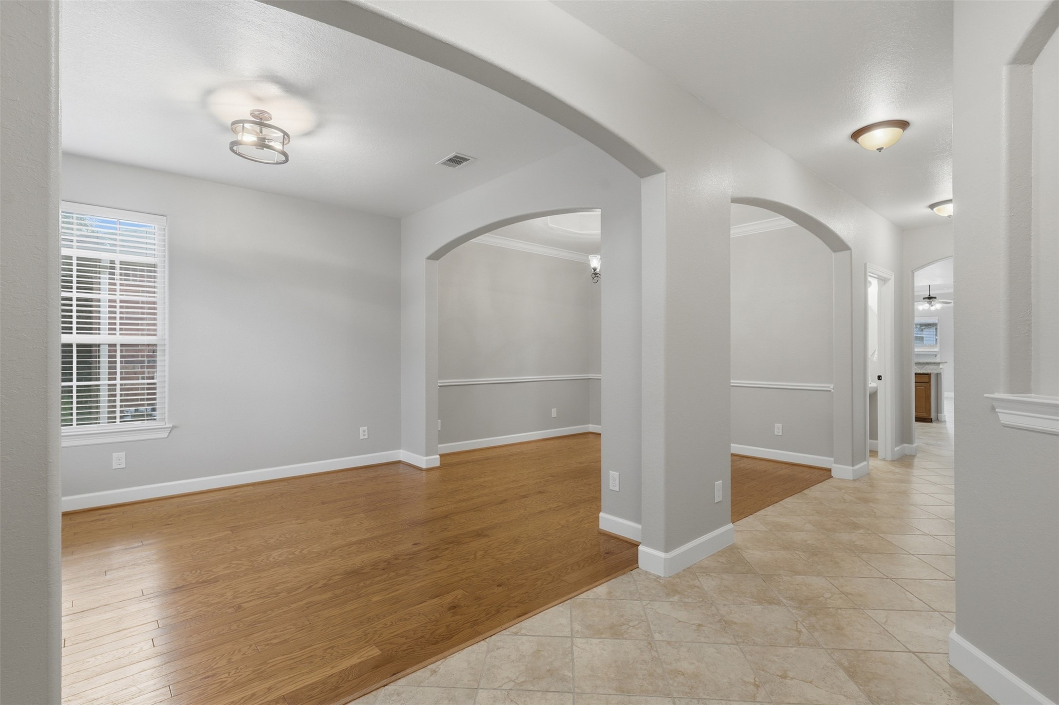 Step inside to discover elegant arched entryways leading to the formal living and dining rooms, where gleaming hardwood floors create a warm first impression. A decorative art niche enhances the foyer, while diagonally laid tile flooring draws you into the home's open living spaces.