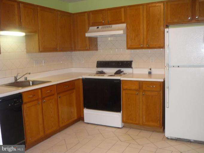8214 Winstead Place, Unit 204 Manassas, VA 20109 - Photo 2 of 7 a utility room with a sink a stove and cabinets