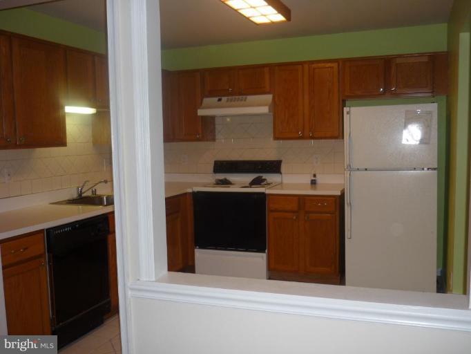 8214 Winstead Place, Unit 204 Manassas, VA 20109 - Photo 3 of 7 a kitchen with a refrigerator and a sink