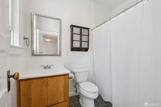 a bathroom with a toilet sink and mirror