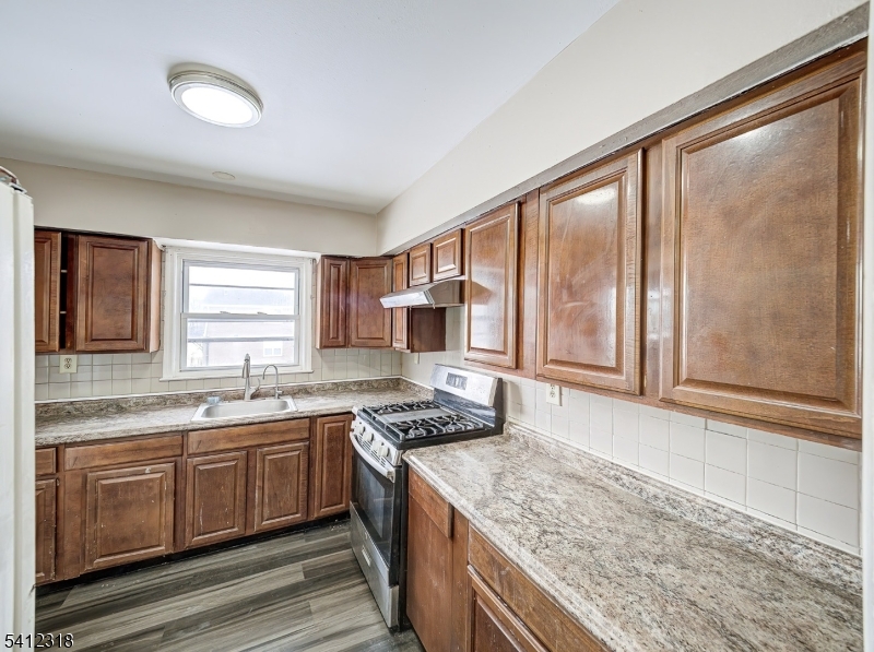 42 Mercer Street Carteret, NJ 07008 - Photo 20 of 35 a kitchen with stainless steel appliances granite countertop a sink stove and cabinets