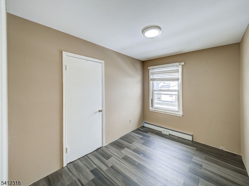 42 Mercer Street Carteret, NJ 07008 - Photo 21 of 35 a view of an empty room with wooden floor and a window