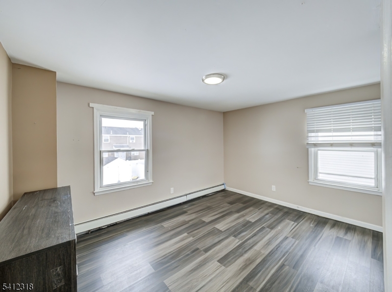42 Mercer Street Carteret, NJ 07008 - Photo 23 of 35 an empty room with wooden floor and windows