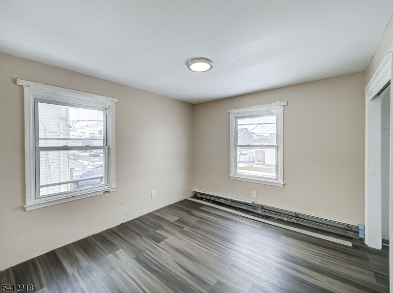 42 Mercer Street Carteret, NJ 07008 - Photo 26 of 35 a view of an empty room with wooden floor and a window