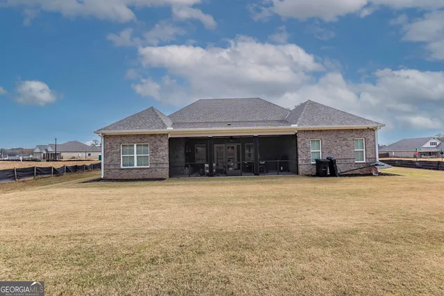 a front view of house with yard and trees in the background