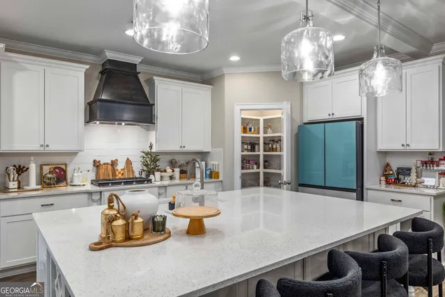 a kitchen with a sink a refrigerator and chairs