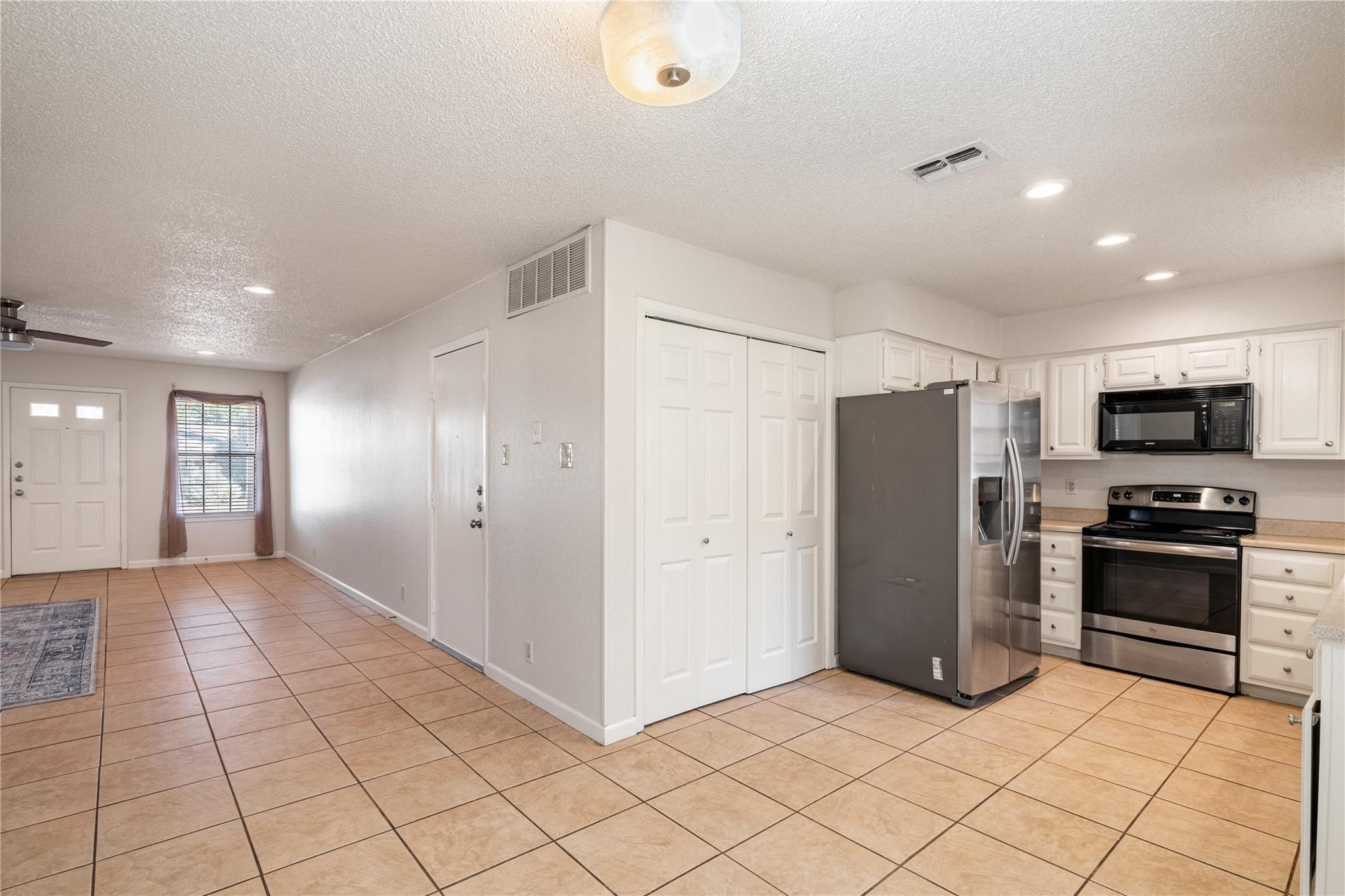 3800 Foust Trail, Unit B Georgetown, TX 78628 - Photo 5 of 16 A contemporary open-concept layout unites the kitchen and living areas, offering cohesive flow and bright tile flooring.