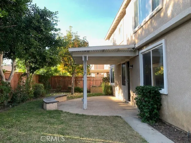 a view of a patio with table and chairs potted plants and floor to ceiling window