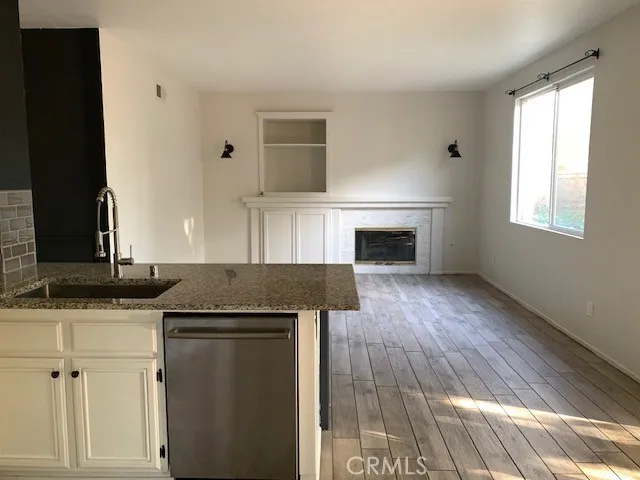 a kitchen with granite countertop a sink cabinets and a wooden floor