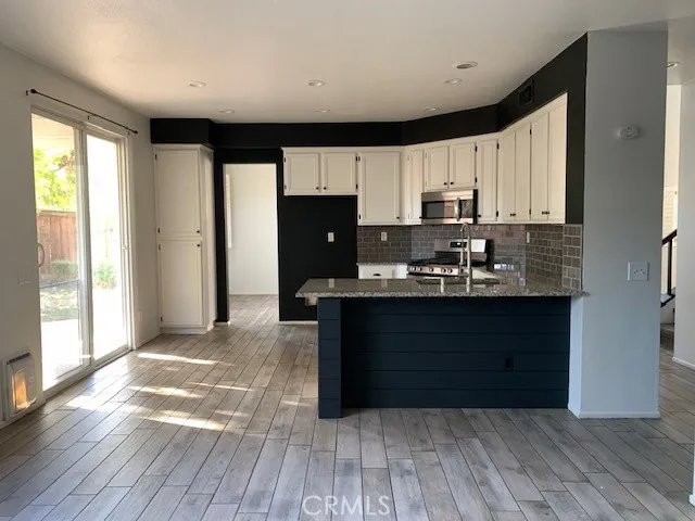 a kitchen with granite countertop a refrigerator and a stove