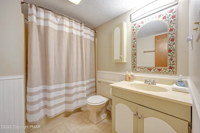 a bathroom with a sink a toilet and shower curtain
