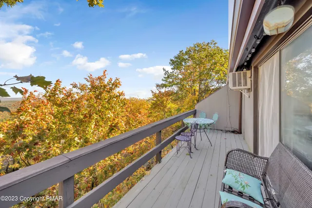 a balcony with wooden floor and furniture