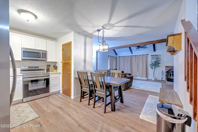 a kitchen with a table chairs microwave and cabinets