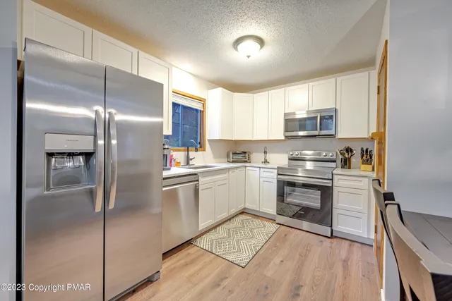 a kitchen with a refrigerator a sink and a stove top oven