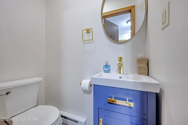a bathroom with a toilet a sink and mirror