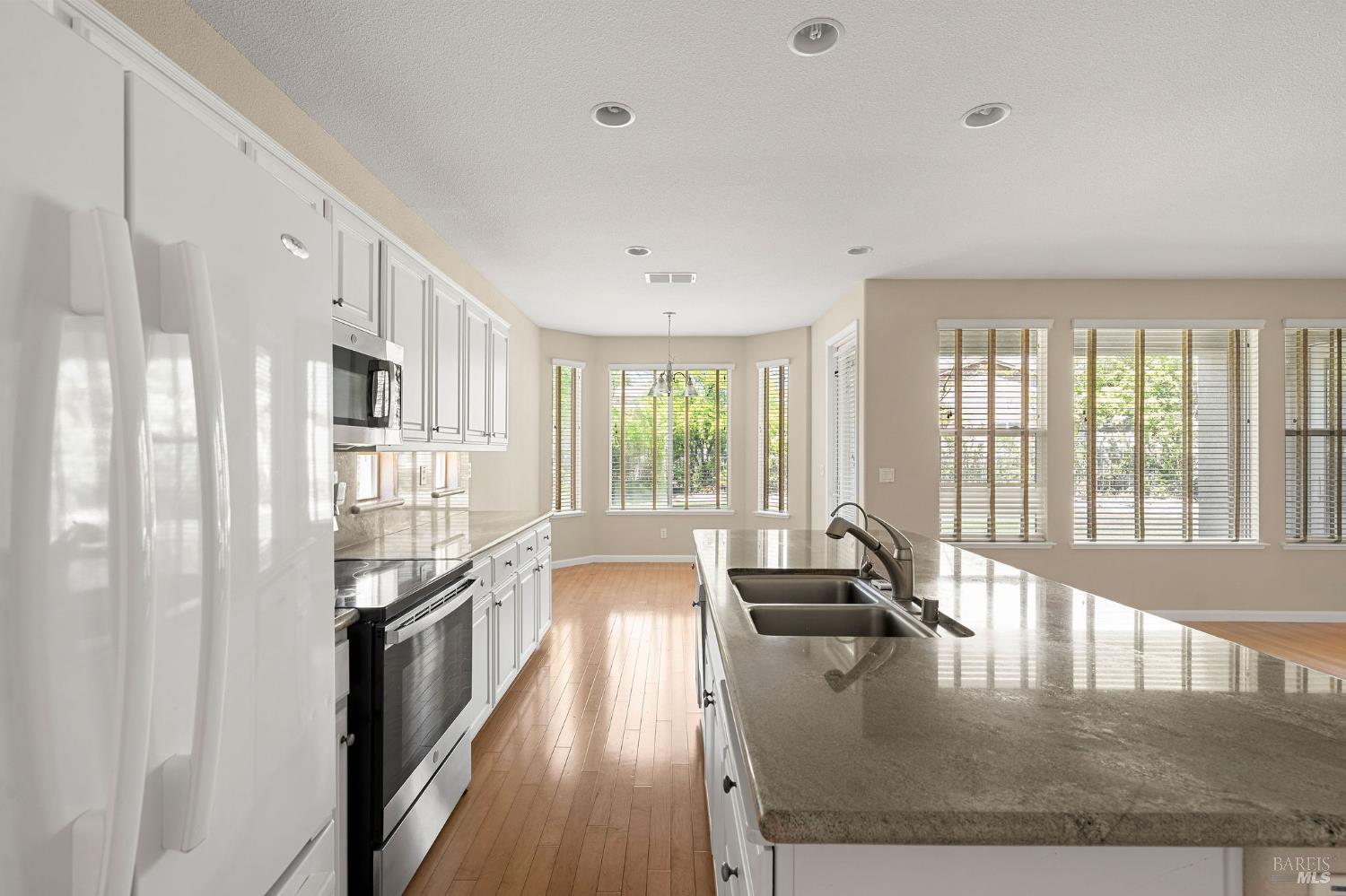 505 Marianna Place Rio Vista, CA 94571 - Photo 13 of 33 a open kitchen with granite countertop a large window a sink and stainless steel appliances