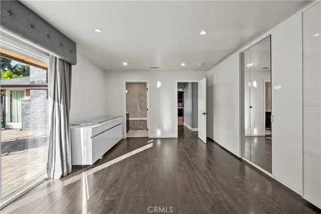 a view of a hallway with wooden floor and windows