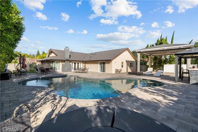a view of house with swimming pool outdoor seating