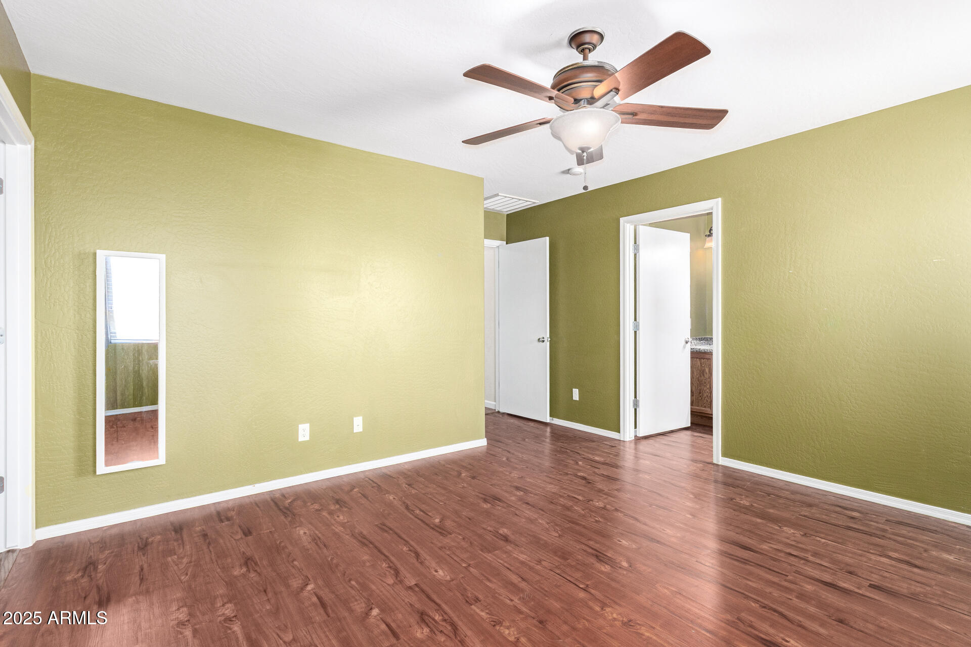 40214 West Lococo Street Maricopa, AZ 85138 - Photo 12 of 31 a view of a big room with wooden floor and a ceiling fan