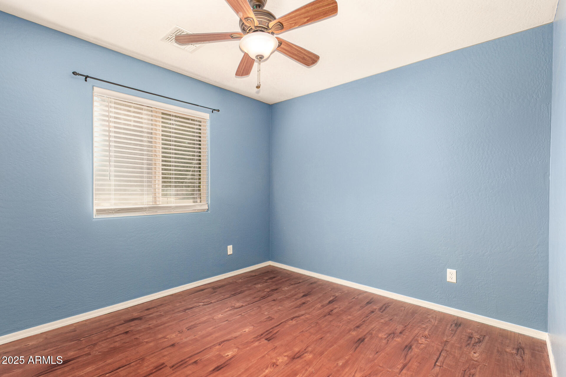 40214 West Lococo Street Maricopa, AZ 85138 - Photo 18 of 31 wooden floor in an empty room with a window