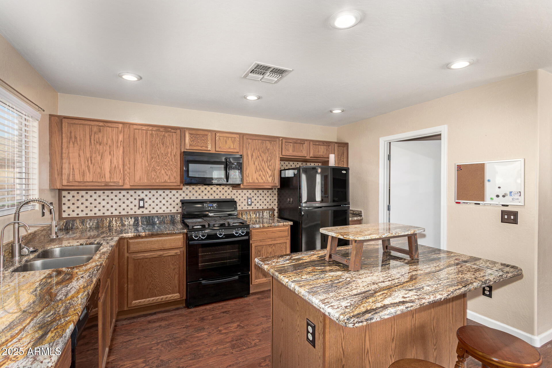 40214 West Lococo Street Maricopa, AZ 85138 - Photo 2 of 31 a kitchen with stainless steel appliances granite countertop a sink stove and refrigerator