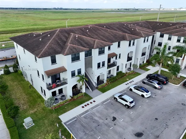 a view of a backyard with lawn chairs under an umbrella
