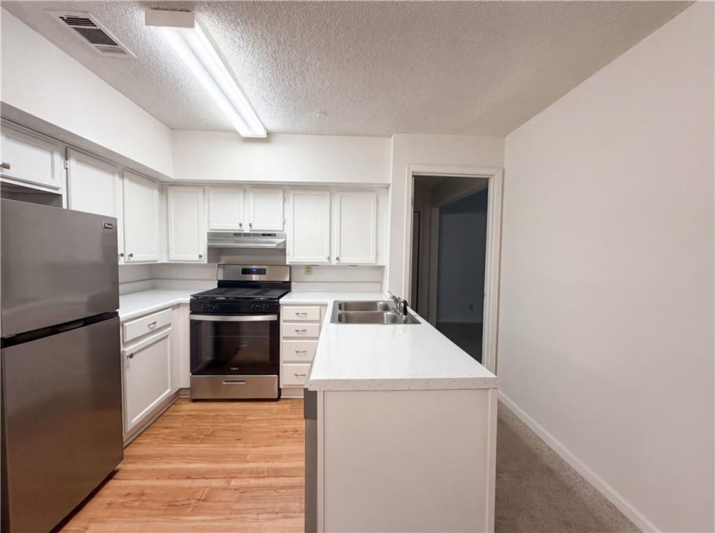573 Cobblestone Trail Avondale Estates, GA 30002 - Photo 6 of 23 a kitchen with granite countertop a refrigerator and a stove top oven