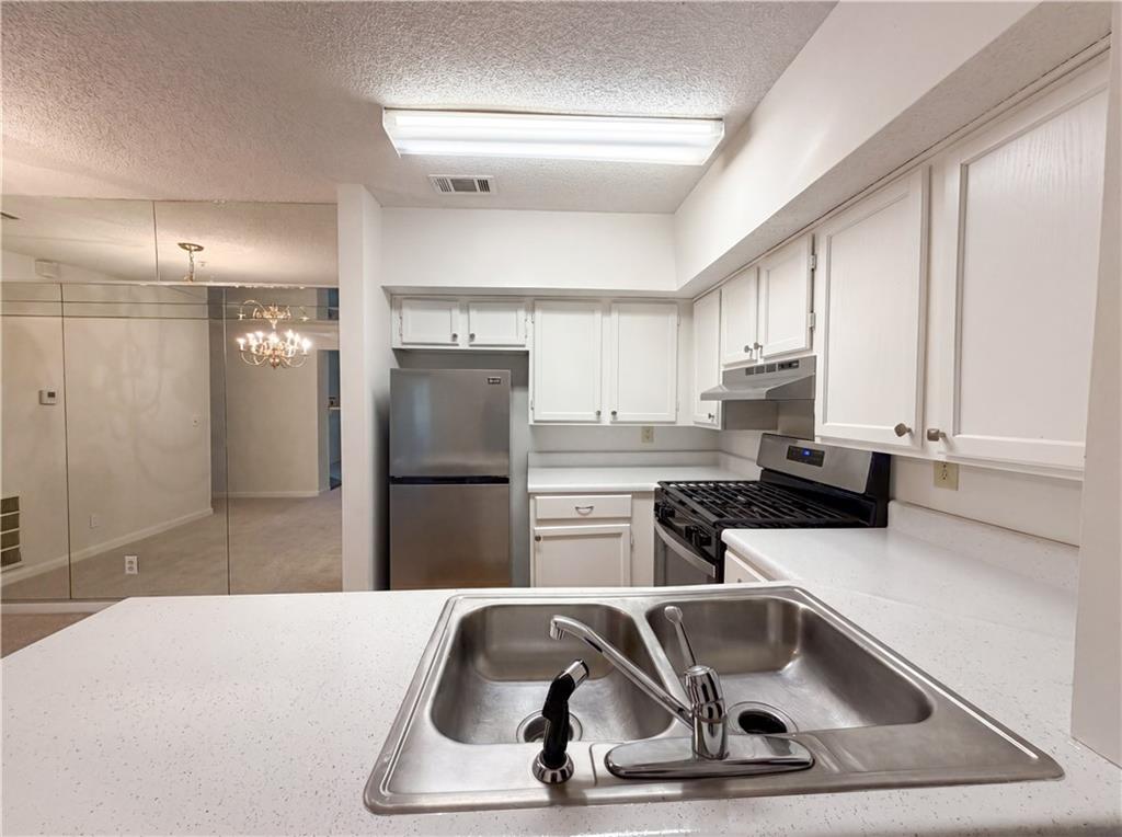 573 Cobblestone Trail Avondale Estates, GA 30002 - Photo 7 of 23 a kitchen with a sink a refrigerator and cabinets