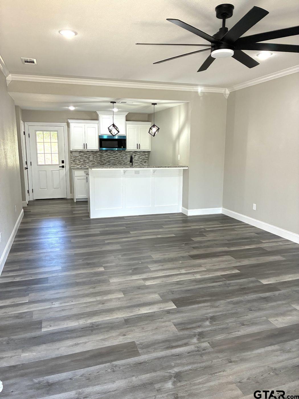1607 North Ross Avenue Tyler, TX 75702 - Photo 2 of 10 a view of a living room with kitchen countertops and wooden floor