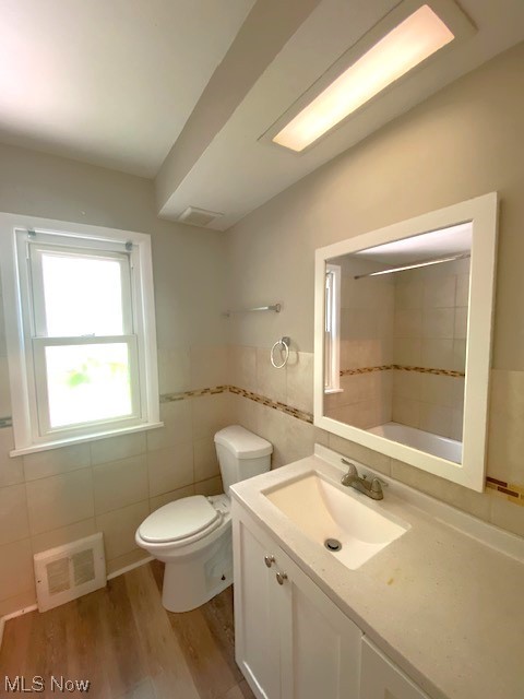 4230 Bluestone Road South Euclid, OH 44121 - Photo 12 of 35 Bathroom featuring toilet, hardwood flooring, tile walls, and oversized vanity