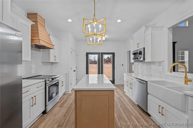 a large kitchen with stainless steel appliances granite countertop a stove a sink dishwasher and a refrigerator