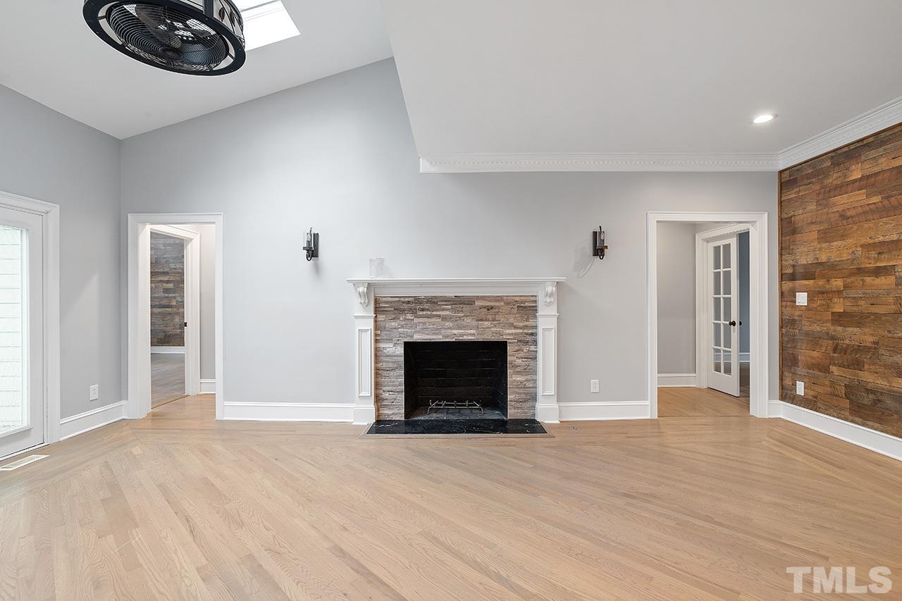 9132 Sutherland Court Raleigh, NC 27615 - Photo 14 of 36 a view of a livingroom with an empty space and a fireplace