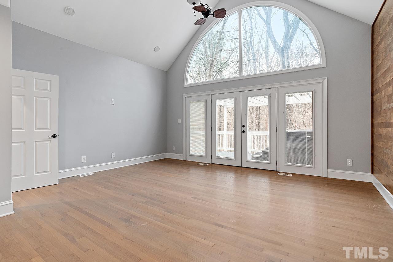 9132 Sutherland Court Raleigh, NC 27615 - Photo 18 of 36 a view of an empty room with wooden floor and a window