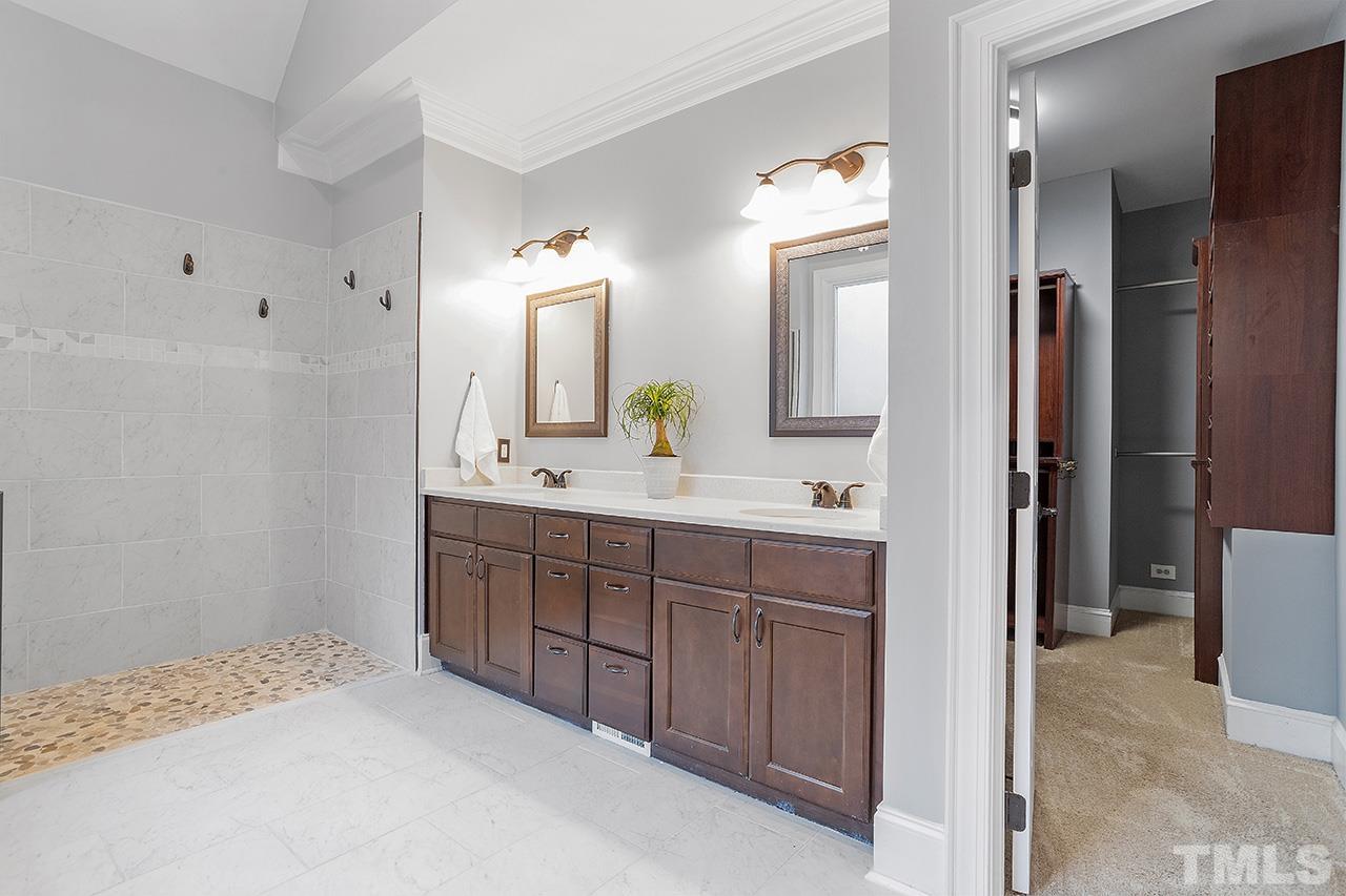 9132 Sutherland Court Raleigh, NC 27615 - Photo 19 of 36 a spacious bathroom with a double vanity sink and a mirror