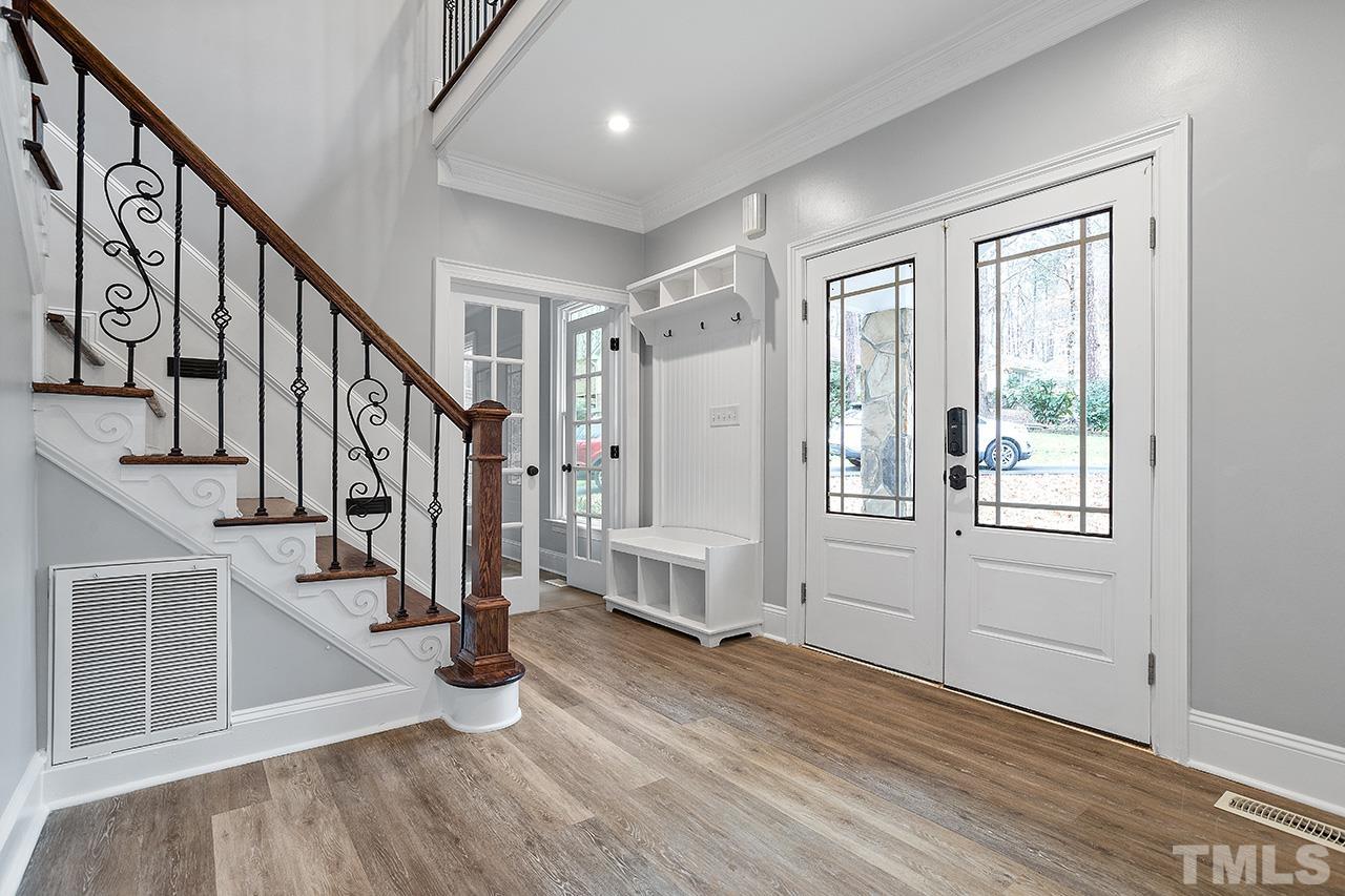 9132 Sutherland Court Raleigh, NC 27615 - Photo 2 of 36 a view of entryway with stairs and wooden floor