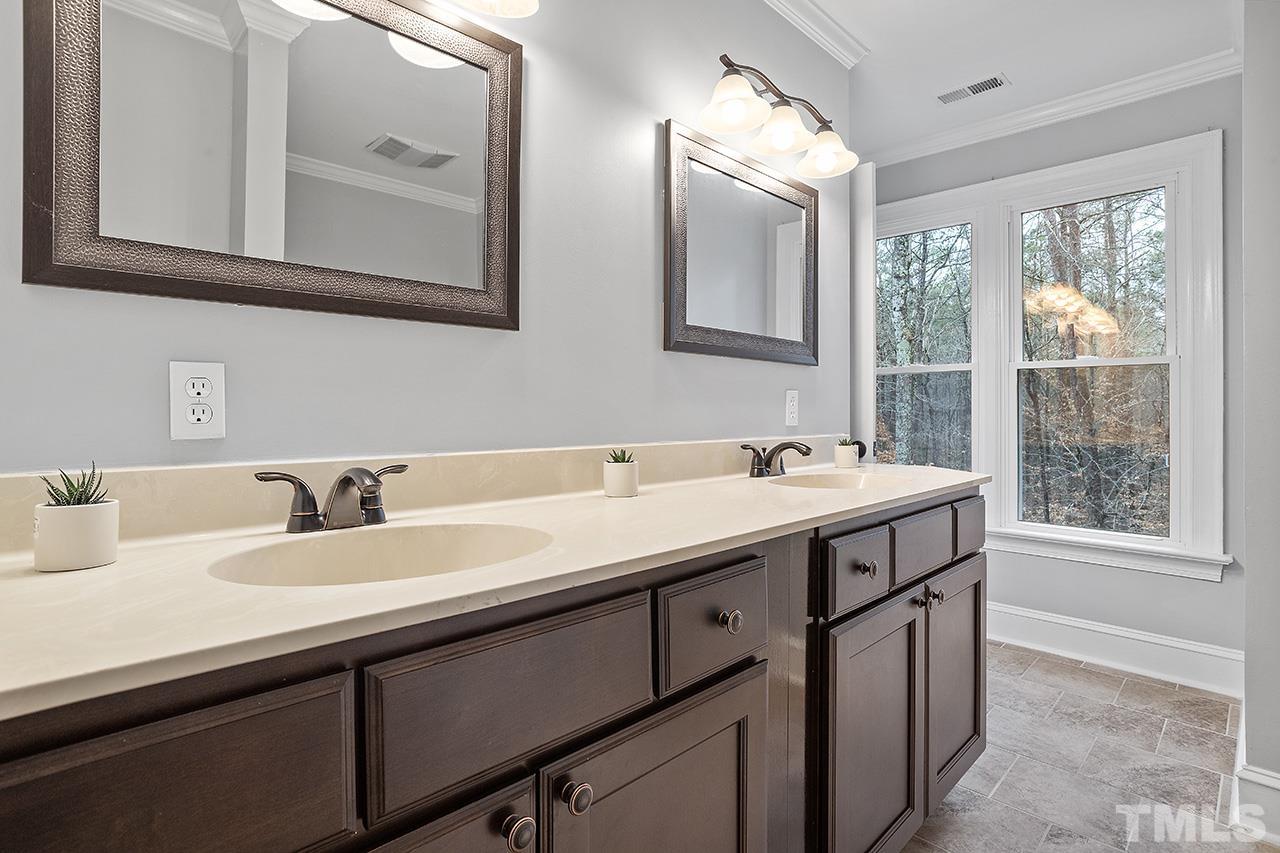 9132 Sutherland Court Raleigh, NC 27615 - Photo 25 of 36 a bathroom with a sink and a mirror