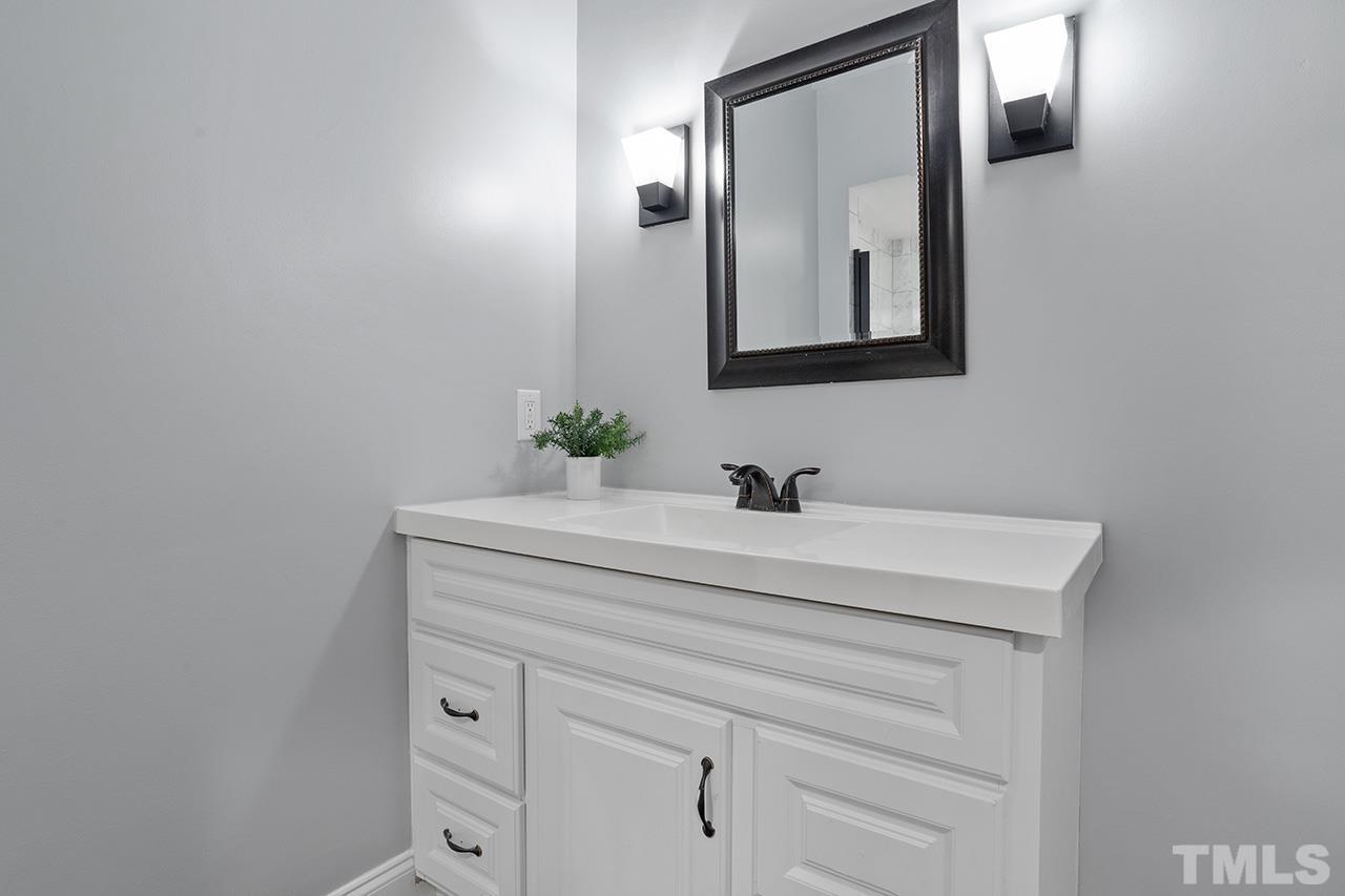 9132 Sutherland Court Raleigh, NC 27615 - Photo 32 of 36 a bathroom with a sink vanity and mirror