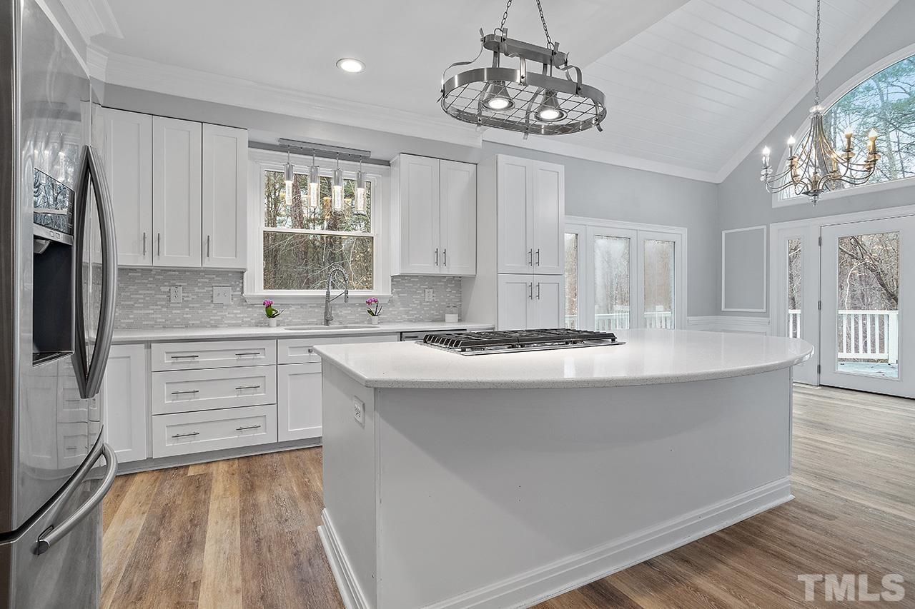 9132 Sutherland Court Raleigh, NC 27615 - Photo 6 of 36 a kitchen with stainless steel appliances granite countertop a stove top oven a refrigerator a sink and dishwasher with wooden floor