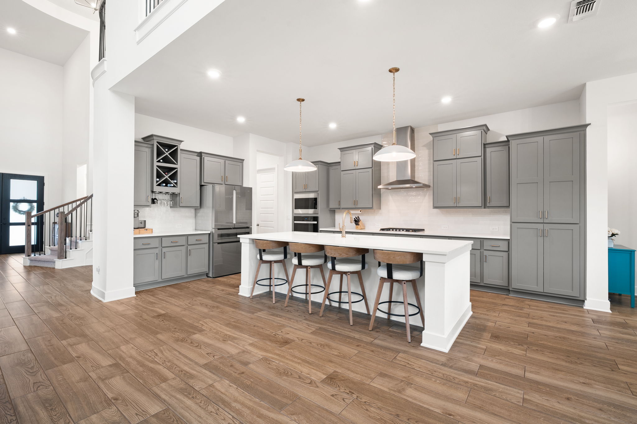 515 Watershield Cove Georgetown, TX 78633 - Photo 13 of 40 A sleek, open-concept kitchen with high ceilings and rich hardwood flooring flows seamlessly into the main living area.