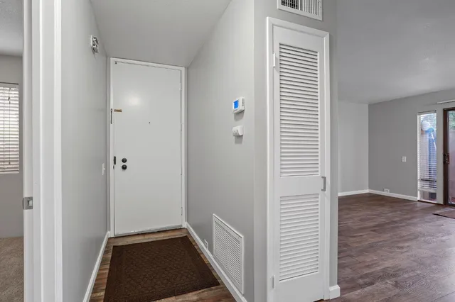 a view of hallway with closet and wooden floor
